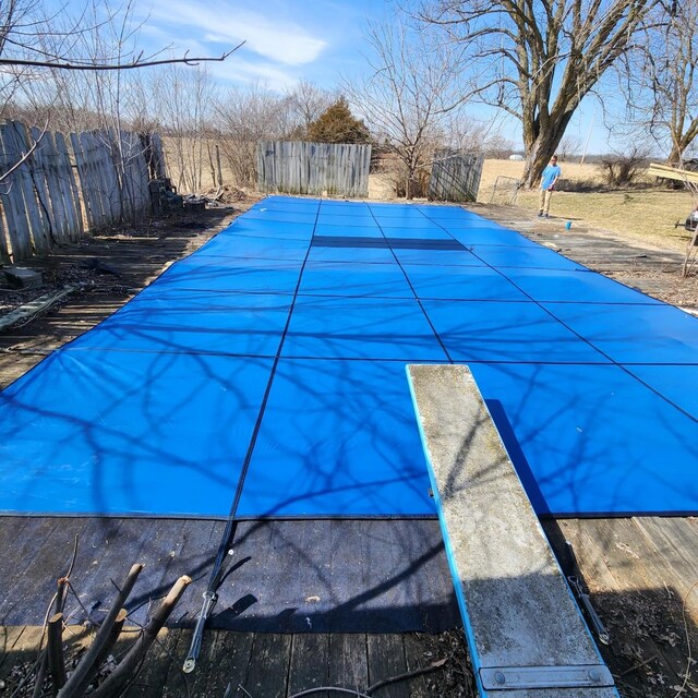 view of swimming pool featuring fence