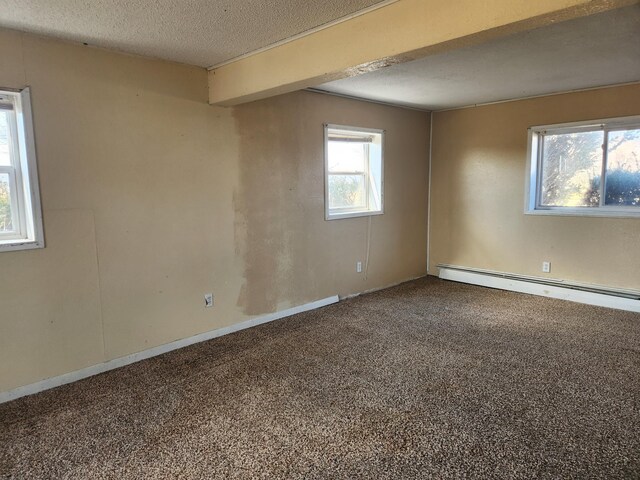 spare room with a textured ceiling, carpet, and a baseboard radiator