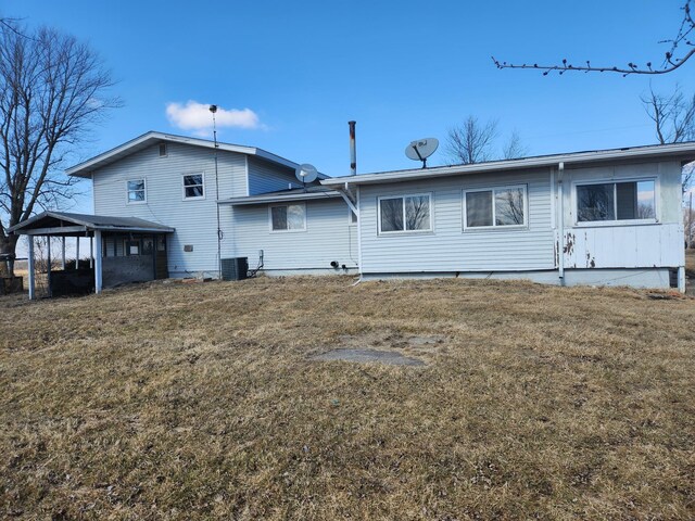 back of property featuring central AC unit and a lawn