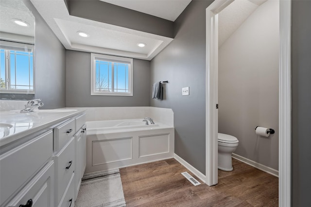 full bath featuring visible vents, toilet, plenty of natural light, wood finished floors, and a bath