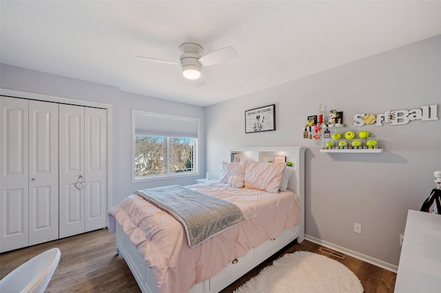 bedroom featuring wood finished floors, visible vents, a closet, and baseboards