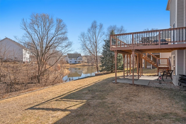 view of yard with a patio, stairway, and a deck with water view