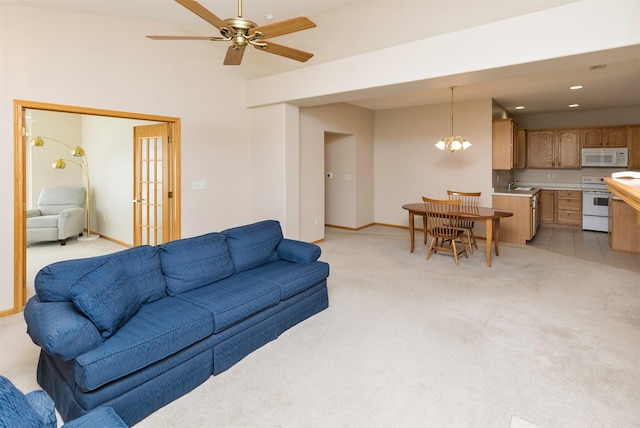 living area featuring recessed lighting, baseboards, light carpet, and ceiling fan with notable chandelier