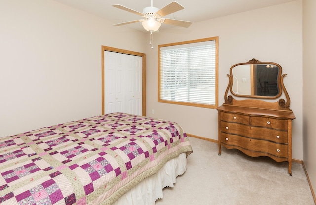 bedroom featuring a closet, light carpet, baseboards, and ceiling fan