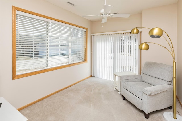 sitting room with a ceiling fan, baseboards, visible vents, and carpet floors