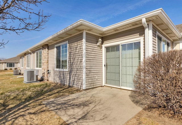 view of side of property with central AC unit and a yard