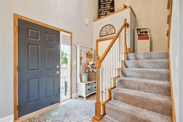 entrance foyer with stairway, baseboards, and wood finished floors