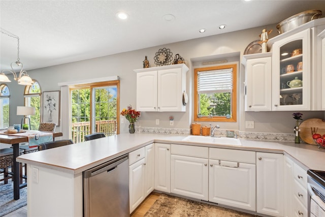 kitchen with a sink, appliances with stainless steel finishes, a peninsula, and light countertops