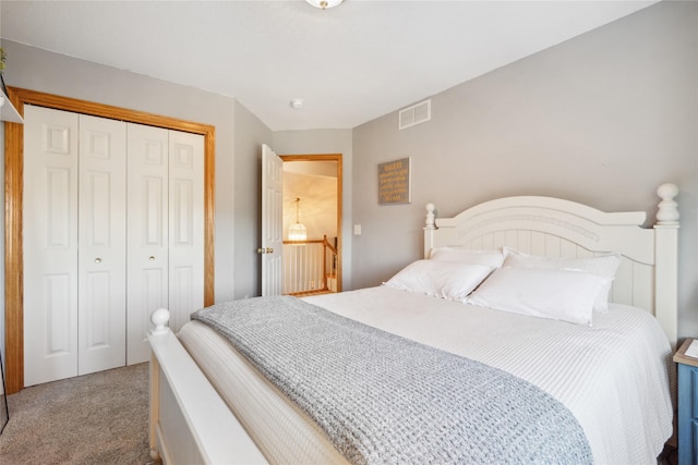 carpeted bedroom with visible vents and a closet