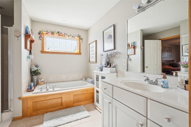 bathroom with tile patterned floors, vanity, a garden tub, and a shower with shower door