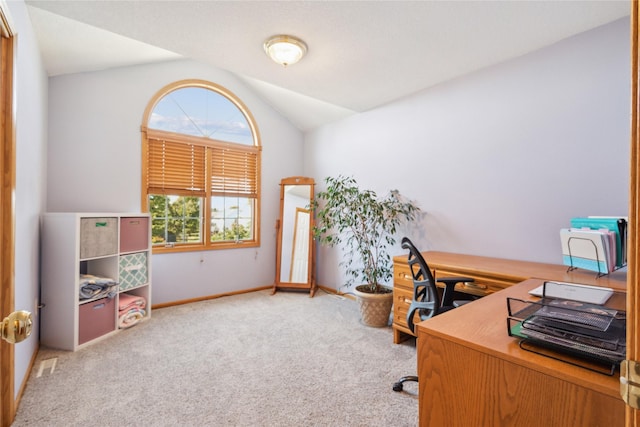 carpeted office featuring lofted ceiling and baseboards