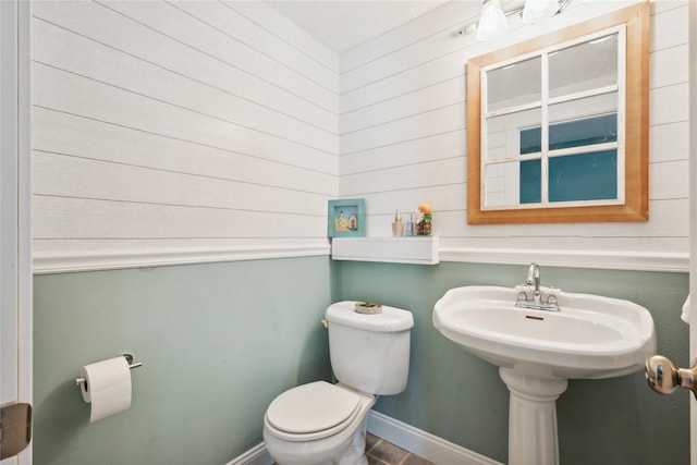 bathroom featuring toilet and baseboards