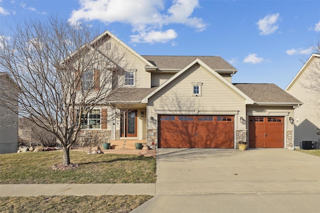 view of front facade with central AC unit, roof with shingles, concrete driveway, a front lawn, and stone siding