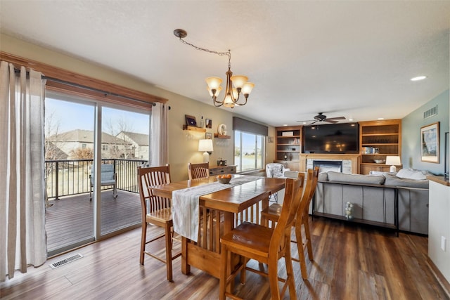 dining room featuring visible vents, a fireplace, and wood finished floors