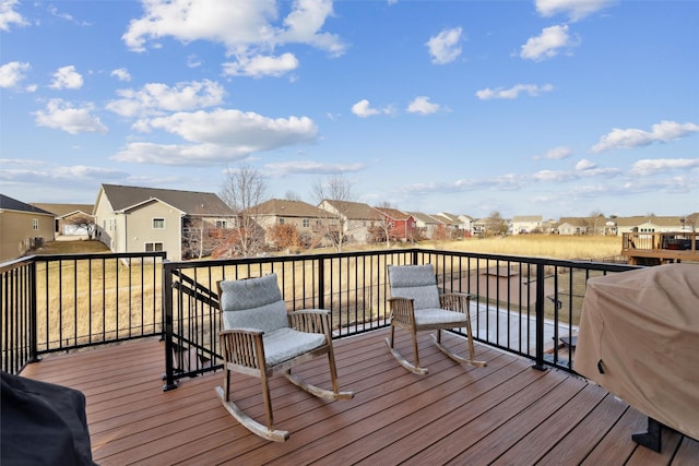 deck featuring a residential view and a grill