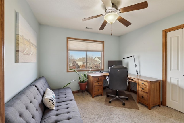 office featuring visible vents, light carpet, and a ceiling fan