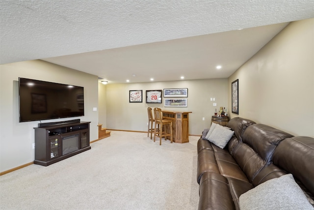 living area featuring a textured ceiling, recessed lighting, a bar, baseboards, and light colored carpet