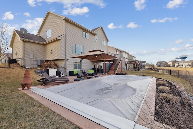 back of house with a gate, a fenced backyard, stairway, a yard, and a patio area