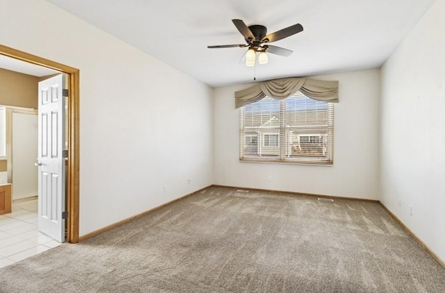 empty room with baseboards, light carpet, and a ceiling fan