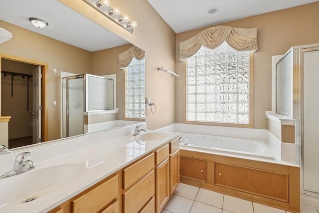 bathroom with tile patterned floors, a garden tub, a stall shower, and a sink