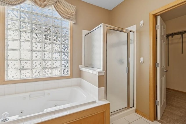 full bath with a tub with jets, a shower stall, and tile patterned flooring