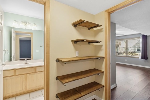 bathroom featuring vanity, wood finished floors, and baseboards