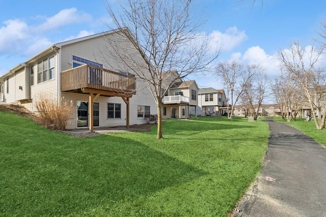 back of house featuring a lawn and a residential view