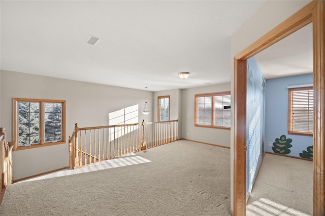 hallway with baseboards and carpet