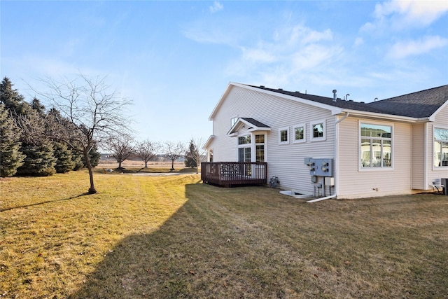 rear view of house featuring a wooden deck and a yard