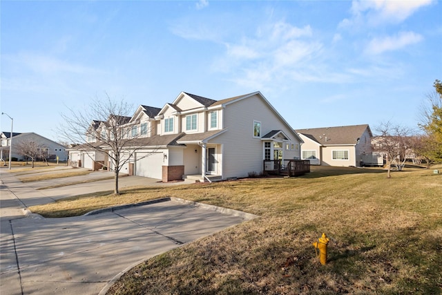 traditional-style house with a residential view, an attached garage, concrete driveway, and a front lawn