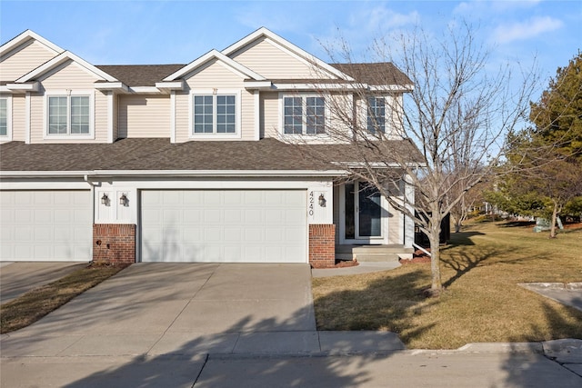 view of property featuring brick siding, concrete driveway, a garage, and a shingled roof