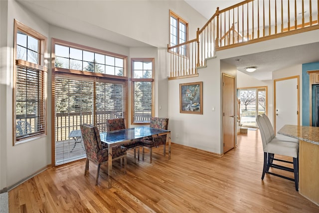 dining space featuring a high ceiling and light wood-style floors