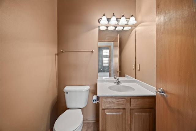 half bathroom with vanity and toilet