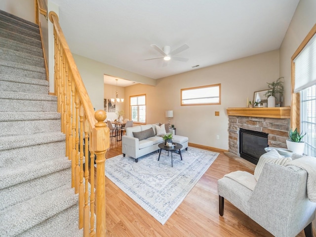 1904 NW Ashton Ln Unit 3, Ankeny, IA 50023 - living area with stairway, wood finished floors, ceiling fan, a stone fireplace, and a chandelier