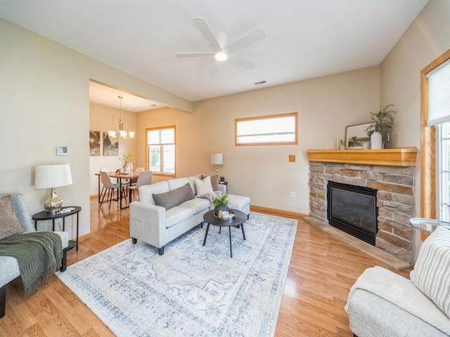 1904 NW Ashton Ln Unit 3, Ankeny, IA 50023 - living area with plenty of natural light, a stone fireplace, a ceiling fan, and light wood-style floors