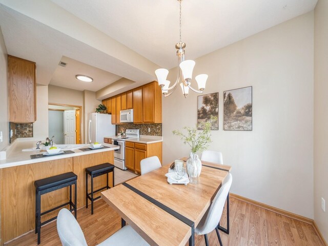 1904 NW Ashton Ln Unit 3, Ankeny, IA 50023 - dining room with a chandelier and light wood finished floors