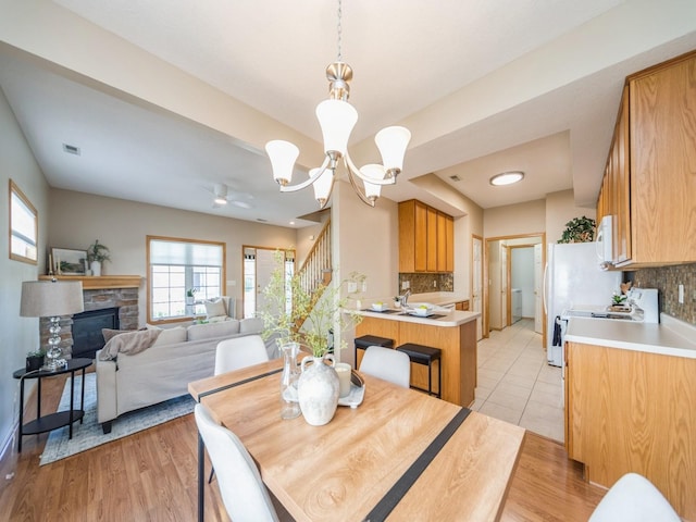 1904 NW Ashton Ln Unit 3, Ankeny, IA 50023 - dining room featuring plenty of natural light, stairs, light wood finished floors, and a stone fireplace