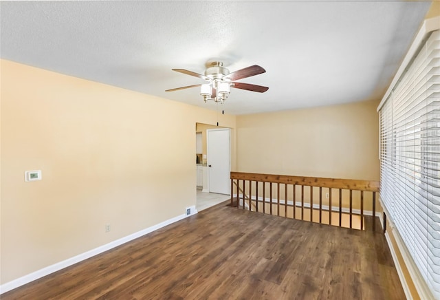 unfurnished room with visible vents, baseboards, wood finished floors, and a ceiling fan