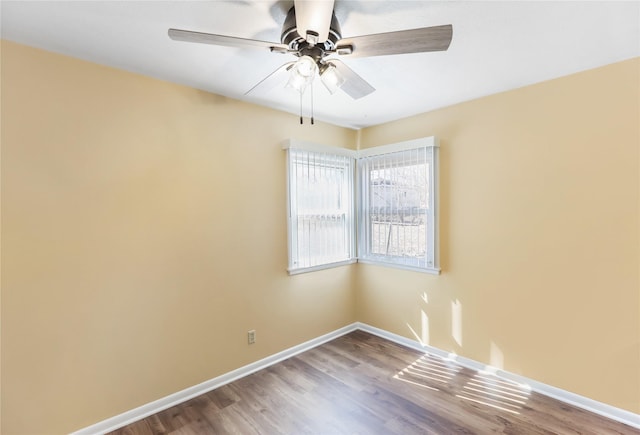 empty room featuring ceiling fan, baseboards, and wood finished floors