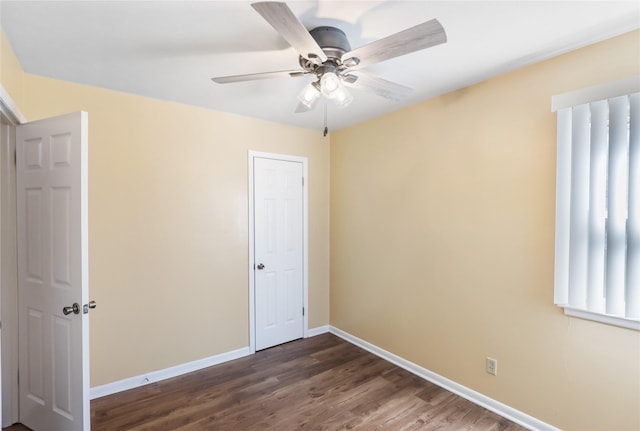 unfurnished bedroom with a ceiling fan, baseboards, and dark wood-style flooring