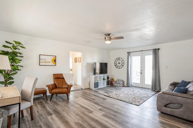 living area with ceiling fan, french doors, and wood finished floors