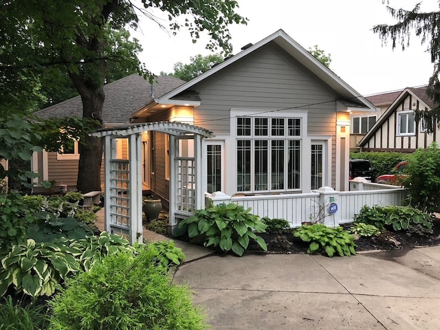 rear view of house with a shingled roof