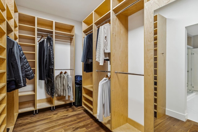 walk in closet with wood finished floors