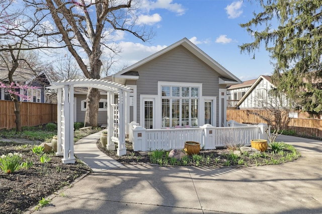 view of front of house with a pergola and fence