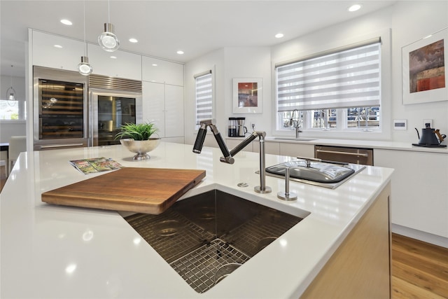 5740 Walnut Hill Ave, Des Moines, IA 50312 - kitchen with dishwasher, a sink, white cabinetry, beverage cooler, and recessed lighting