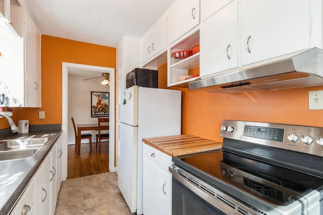 kitchen with under cabinet range hood, a sink, freestanding refrigerator, stainless steel electric range, and white cabinets