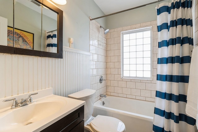 full bath with visible vents, toilet, wainscoting, shower / tub combo, and vanity