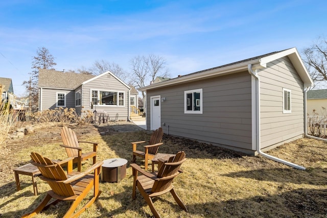 back of property featuring an outbuilding and a fire pit