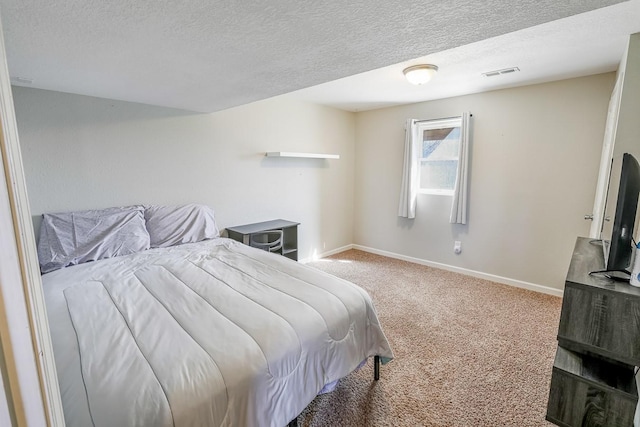 carpeted bedroom featuring baseboards, visible vents, and a textured ceiling