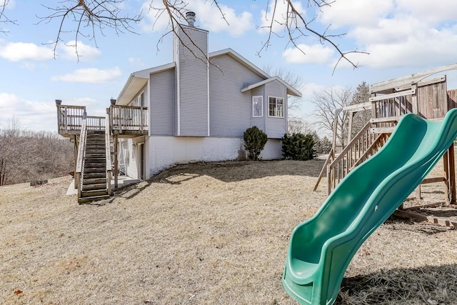 view of jungle gym with a wooden deck and stairs